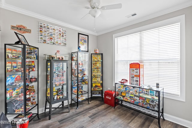 rec room with visible vents, wood finished floors, crown molding, baseboards, and ceiling fan