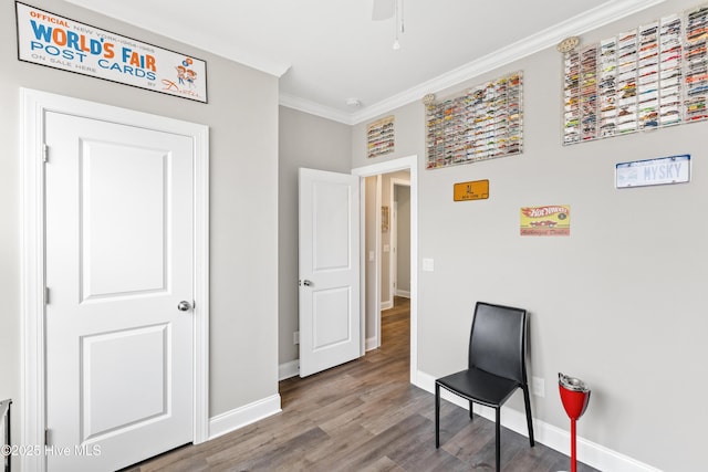 sitting room featuring baseboards, a ceiling fan, wood finished floors, and crown molding