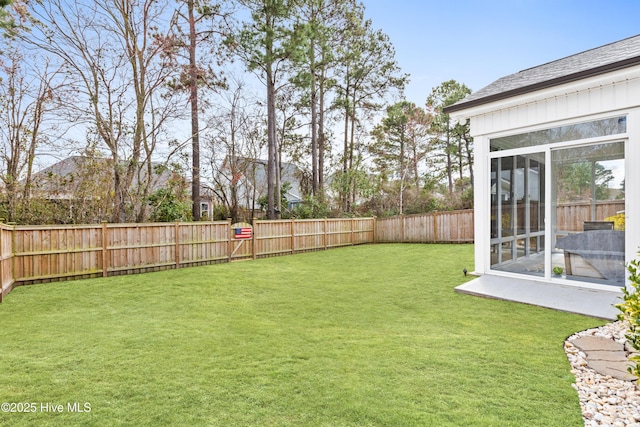 view of yard with a fenced backyard and a sunroom