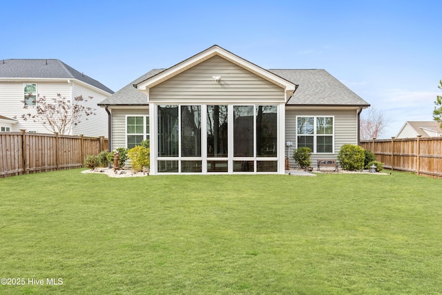 back of property featuring a lawn, roof with shingles, a fenced backyard, and a sunroom