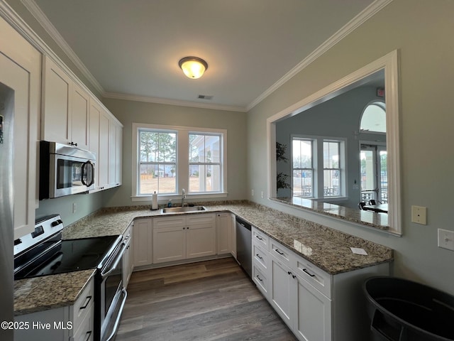 kitchen featuring ornamental molding, visible vents, appliances with stainless steel finishes, and a sink