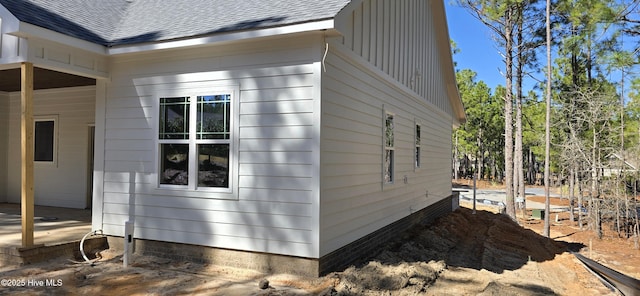 view of side of property with roof with shingles