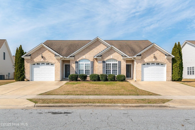 single story home with an attached garage, brick siding, and driveway