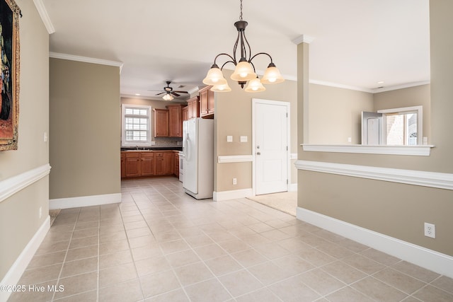 interior space featuring tasteful backsplash, ornamental molding, light tile patterned floors, white fridge with ice dispenser, and brown cabinetry