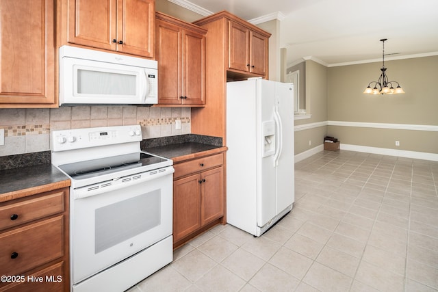 kitchen with dark countertops, white appliances, an inviting chandelier, brown cabinetry, and crown molding