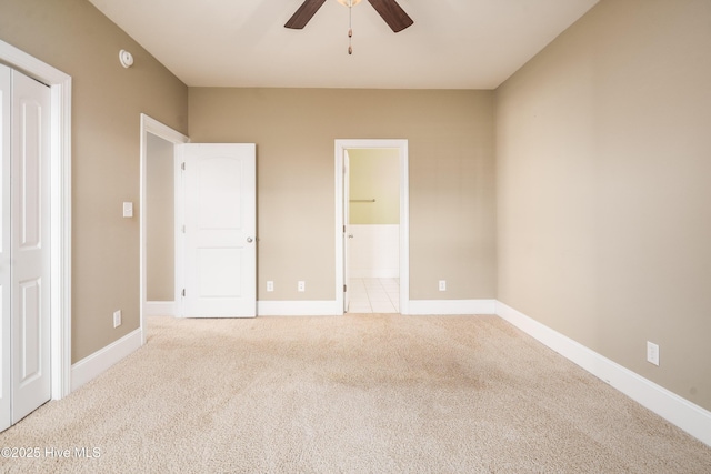 unfurnished bedroom with ceiling fan, baseboards, ensuite bath, and carpet flooring