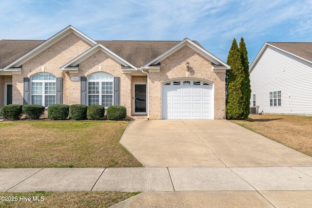 single story home featuring brick siding, concrete driveway, and a front lawn