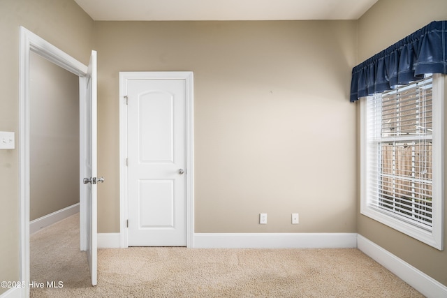 interior space featuring baseboards and carpet