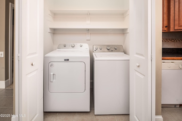 laundry area with laundry area, light tile patterned flooring, and separate washer and dryer