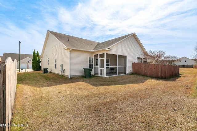 rear view of property with a lawn, fence, roof with shingles, a sunroom, and central AC unit