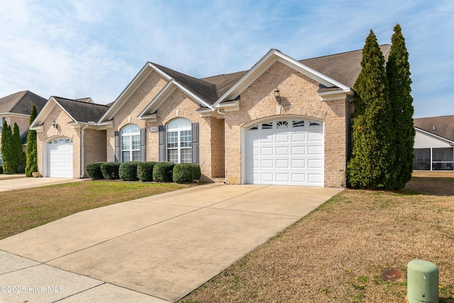 ranch-style house with a front yard, brick siding, a garage, and driveway