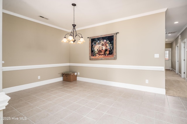 carpeted spare room with tile patterned flooring, visible vents, baseboards, a chandelier, and ornamental molding