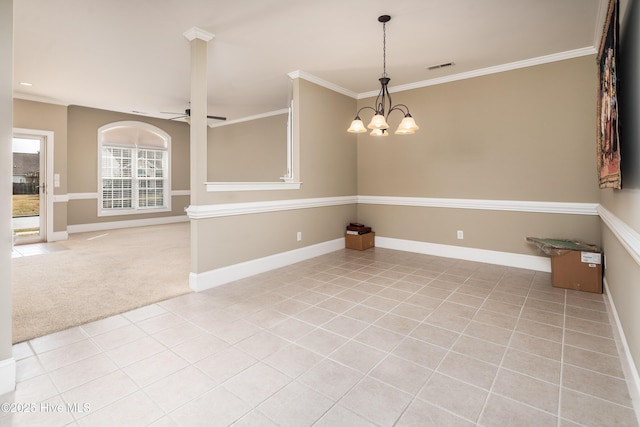 carpeted spare room with tile patterned floors, visible vents, baseboards, and ornamental molding