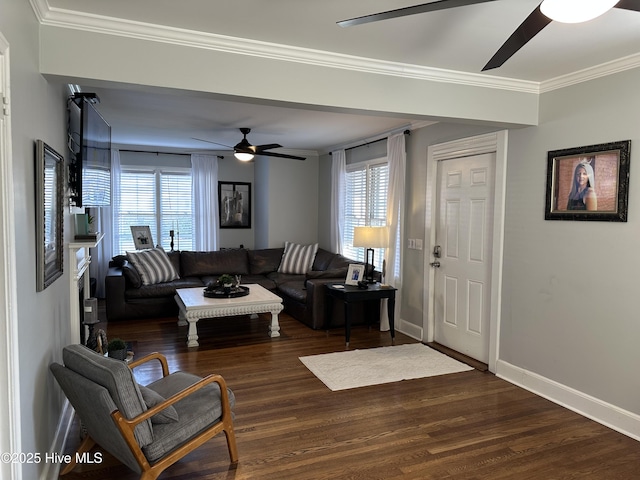 living area with baseboards, dark wood finished floors, a ceiling fan, and ornamental molding