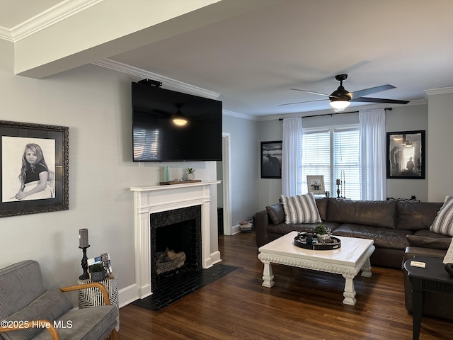 living area with a fireplace with flush hearth, wood finished floors, ornamental molding, and a ceiling fan