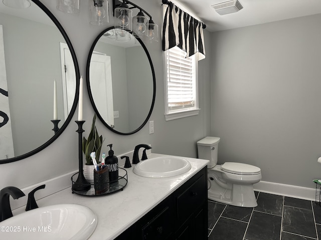 full bath featuring double vanity, visible vents, toilet, and a sink