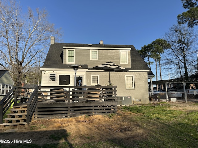 back of house featuring a wooden deck, central AC unit, a chimney, and fence