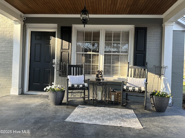 entrance to property featuring brick siding and a porch