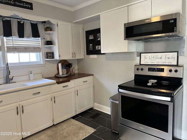 kitchen featuring open shelves, crown molding, appliances with stainless steel finishes, white cabinets, and a sink