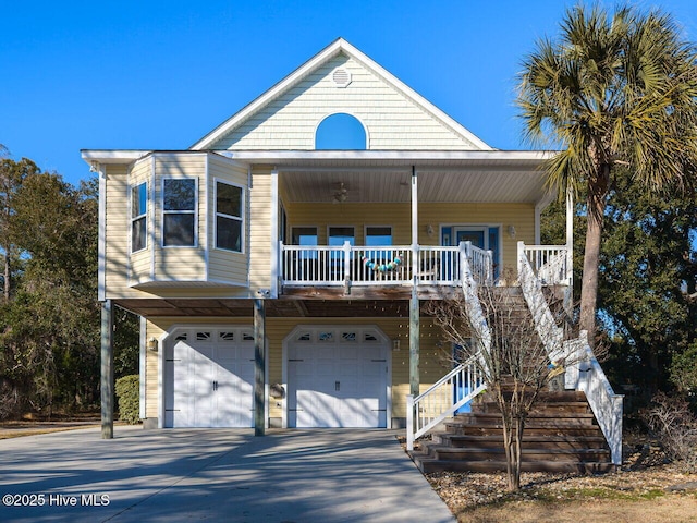 view of front of property featuring stairs, a porch, concrete driveway, and a garage