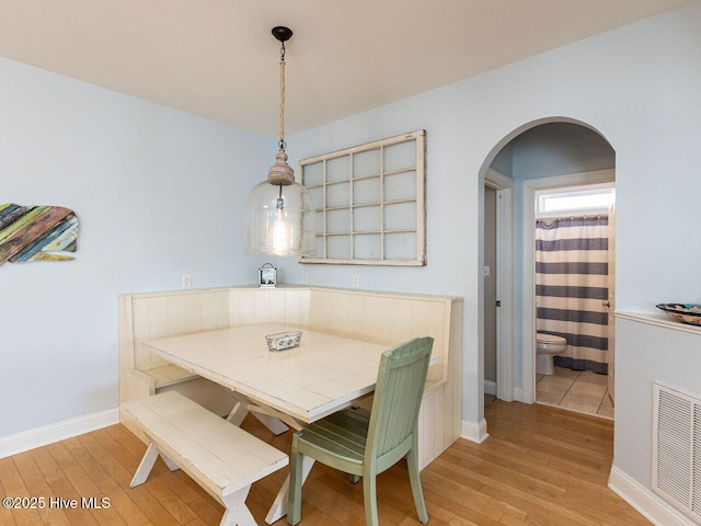 129 Sunset Dr, Cedar Point, NC 28584 - dining space featuring arched walkways, visible vents, light wood finished floors, and baseboards