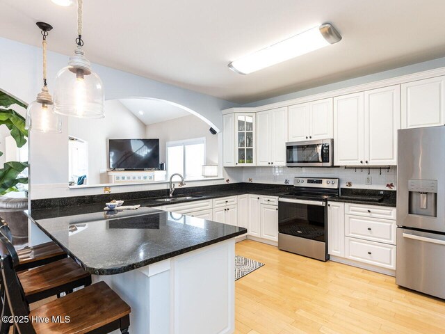 129 Sunset Dr, Cedar Point, NC 28584 - kitchen with a sink, a peninsula, white cabinets, and stainless steel appliances