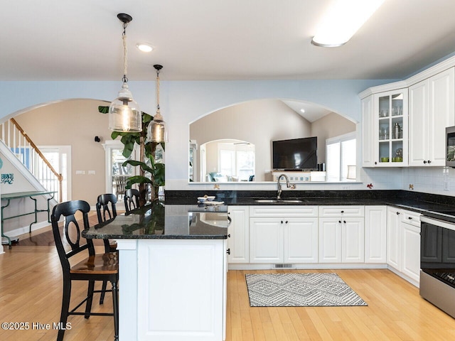 129 Sunset Dr, Cedar Point, NC 28584 - kitchen featuring light wood-style flooring, a sink, glass insert cabinets, appliances with stainless steel finishes, and white cabinetry