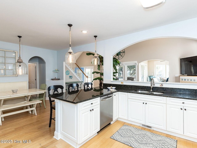 129 Sunset Dr, Cedar Point, NC 28584 - kitchen with visible vents, light wood-type flooring, a sink, white cabinets, and dishwasher