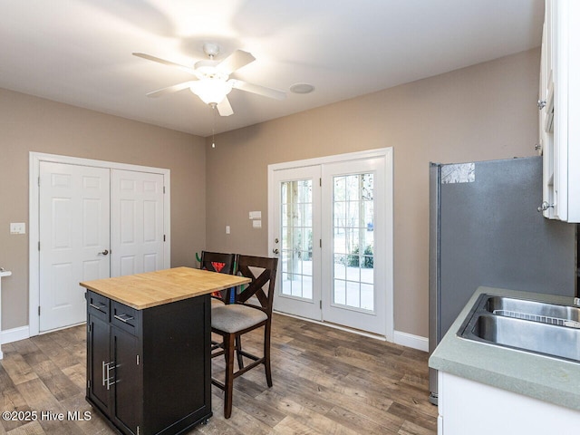129 Sunset Dr, Cedar Point, NC 28584 - kitchen with a kitchen breakfast bar, dark cabinetry, wood finished floors, white cabinetry, and butcher block counters