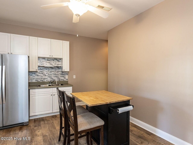 129 Sunset Dr, Cedar Point, NC 28584 - dining area featuring visible vents, ceiling fan, baseboards, and dark wood-style flooring