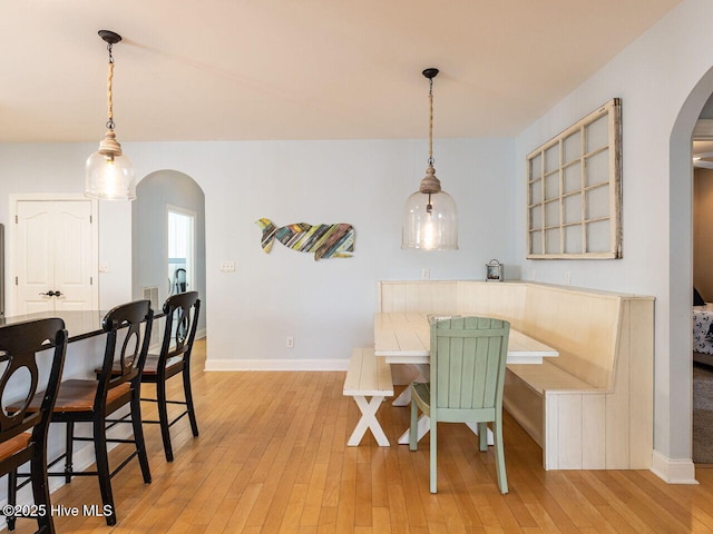 129 Sunset Dr, Cedar Point, NC 28584 - dining area featuring arched walkways, light wood-type flooring, and baseboards