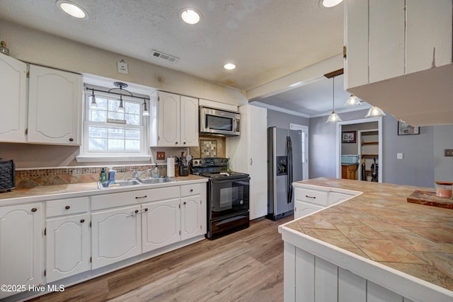 kitchen featuring visible vents, light wood finished floors, a sink, appliances with stainless steel finishes, and white cabinetry