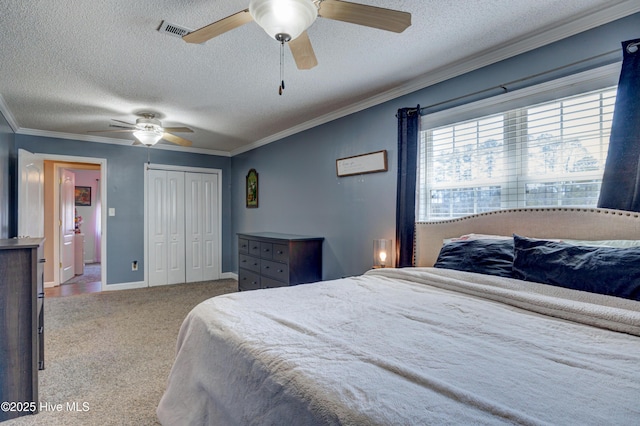 carpeted bedroom featuring a closet, visible vents, ceiling fan, and ornamental molding