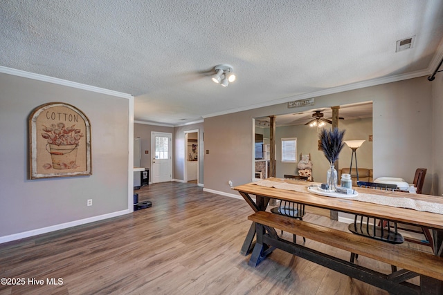 dining room with visible vents, a ceiling fan, a textured ceiling, wood finished floors, and baseboards