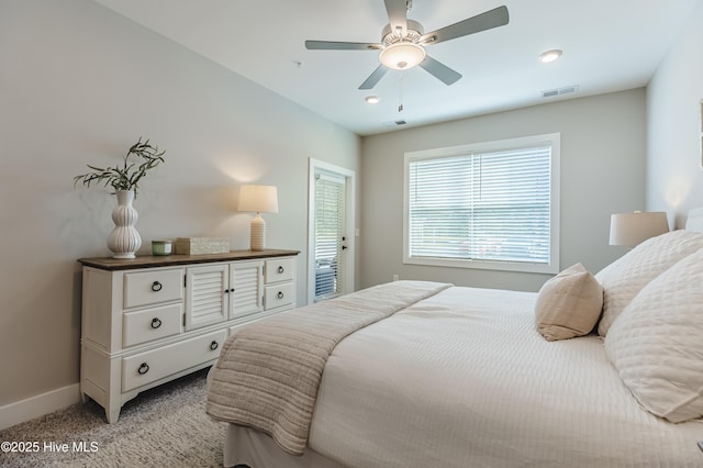 bedroom with visible vents, light carpet, baseboards, and a ceiling fan