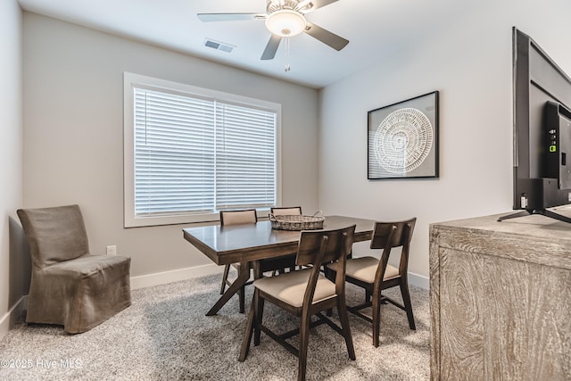 carpeted dining room featuring visible vents, baseboards, and a ceiling fan