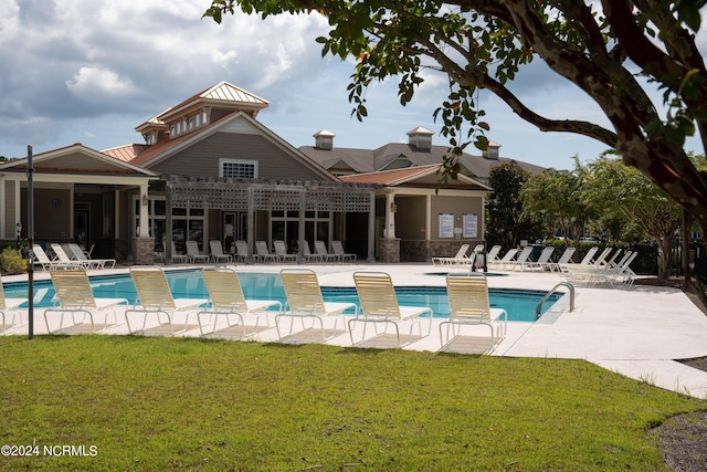 pool featuring fence, a lawn, and a patio area