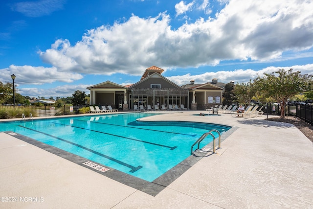 pool with fence and a patio area