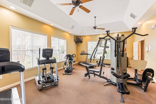 exercise area with visible vents, recessed lighting, a raised ceiling, and baseboards