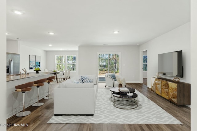 living room featuring recessed lighting, wood finished floors, and baseboards