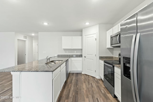 kitchen with visible vents, dark wood finished floors, a peninsula, a sink, and appliances with stainless steel finishes