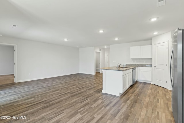 kitchen with visible vents, a peninsula, a sink, stainless steel appliances, and white cabinetry