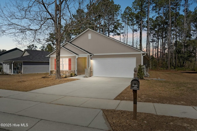 view of front of house with stone siding, driveway, an attached garage, and a front yard