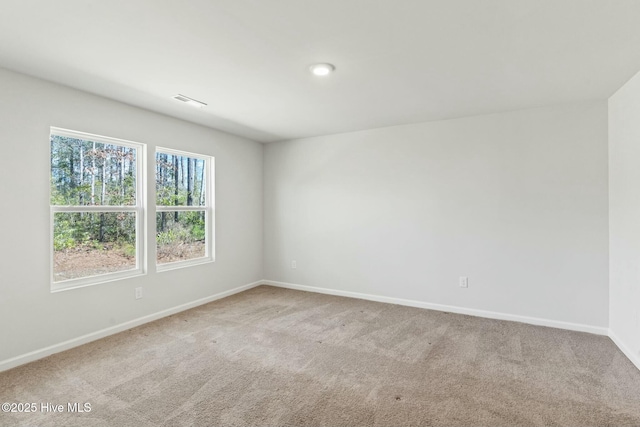 carpeted empty room featuring visible vents and baseboards