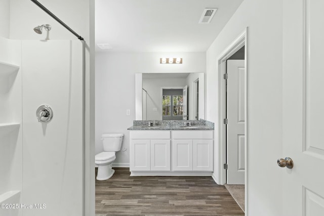 full bath with wood finished floors, visible vents, a sink, walk in shower, and toilet