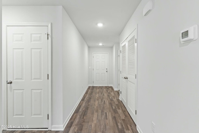 corridor with baseboards and dark wood finished floors