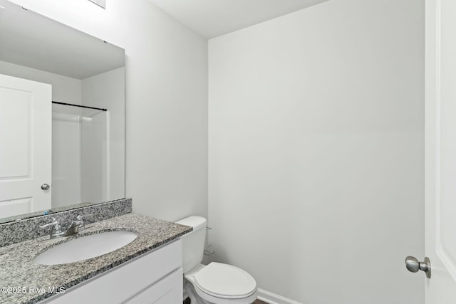 bathroom with vanity, toilet, and baseboards