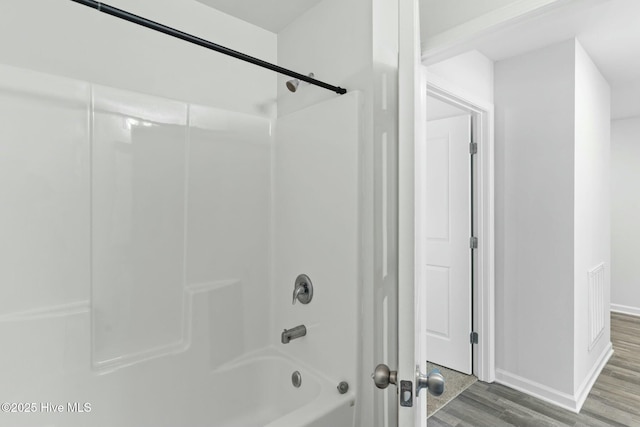 full bathroom with visible vents, wood finished floors, baseboards, and shower / bathtub combination