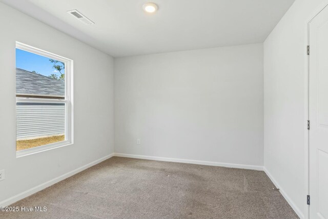 empty room with visible vents, baseboards, and carpet flooring