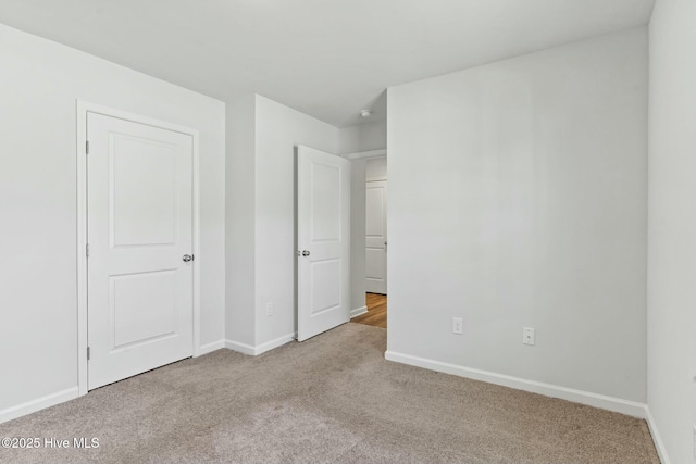 unfurnished bedroom with carpet flooring and baseboards